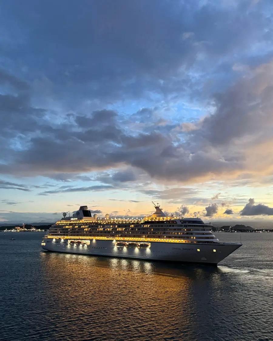 A cruise ship lit at dusk on the open sea