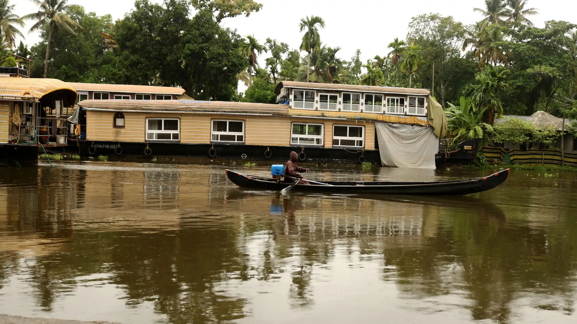 Houseboats and a canoe on the backwaters of Alappuzha, Kerala